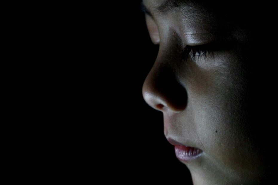 “Side‑profile of a contemplative child in low light, representing the invisible emotional burdens children bear at home.”